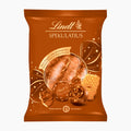A package of Lindt Spekulatius Speculoos pralines on a plain white background. The packaging is a rich brown with gold accents, featuring illustrations of chocolate pralines and a biscuit.