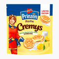 A package of Prinzen Rolle Cremys lemon buttermilk style sandwich cookies, featuring a yellow and blue bag with an illustration of the brand's mascot in a red royal costume, alongside images of the cookies and lemons.