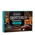 Roshen Shooters Chocolates Rum Liqueur packaging with glasses of rum and chocolates on a wooden surface.