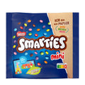 A package of Nestle Smarties Mini chocolate lentils, showing the product name and a variety of colorful chocolate pieces on a blue background. The package indicates that it is made with sugar, has 13 portions, and is suitable for ages 3 and up.