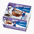 A boxed Milka Oreo Snowballs dessert product shown at an angle on a plain white studio background. The package is predominantly purple and blue with winter-themed illustrations, including a snowman, children, and a bowl of chocolate-covered ice cream spheres with cookie pieces.