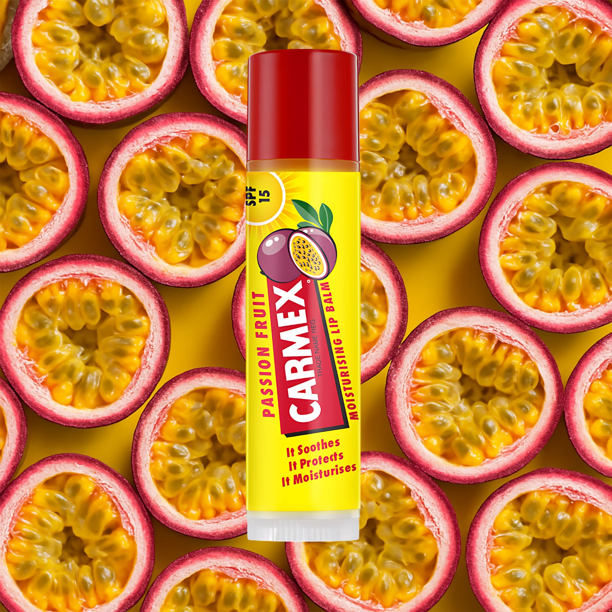 Carmex Passion Fruit lip balm stick surrounded by passion fruit slices on a yellow background