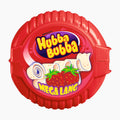 A red circular container of Wringley's Hubba Bubba Mega Long Strawberry chewing gum, featuring the brand logo and illustrations of strawberry-flavored gum pieces on a white background.
