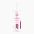 A bottle of The Silky Way Heat Protection Spray on a clean white background. The bottle is frosted white with pink and metallic rose gold text and graphics, and features a white spray nozzle.