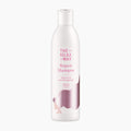 A white bottle of The Silky Way Repair Shampoo with pink text and a pink hair graphic on a light gray background.