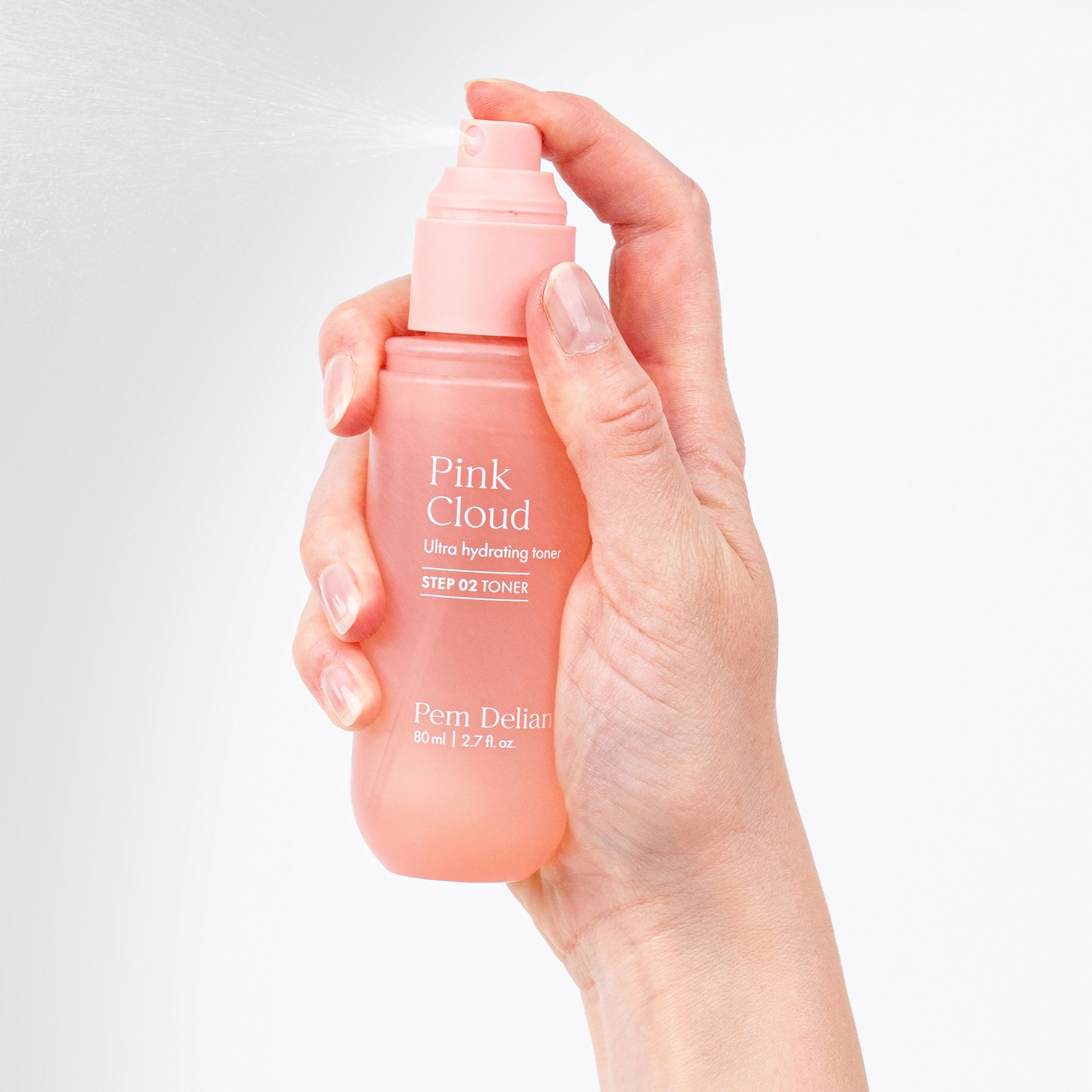 Hand holding a Pem Delian Pink Cloud toner bottle against a light gray background