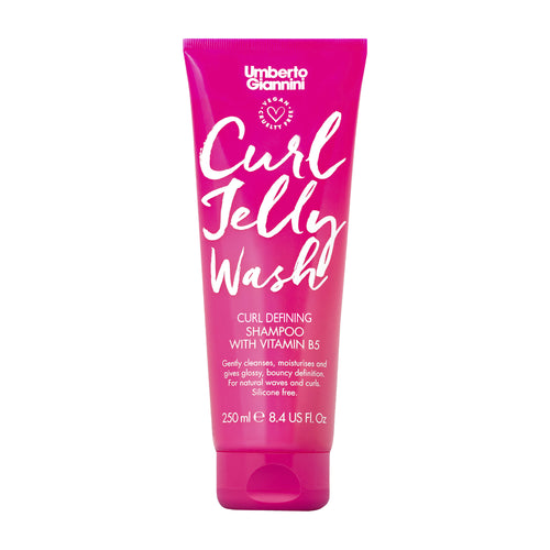 Pink shampoo tube labeled 'Umberto Giannini Curl Jelly Wash' on a white background