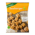 Package of Seeberger walnut kernels with a wooden background