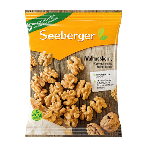 Package of Seeberger walnut kernels with a wooden background