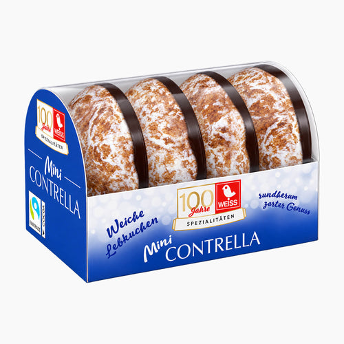 Four mini Weiss Contrella gingerbreads in a clear-lidded blue bakery display box with German text and a Fairtrade logo, photographed on a light gray background.